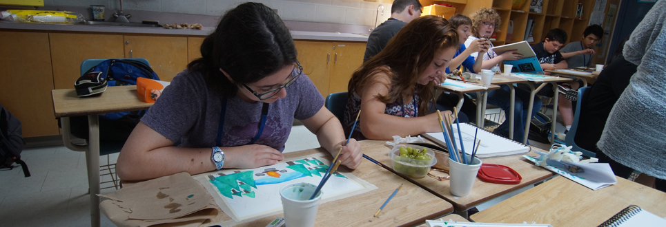Two female students painting in  a classroom